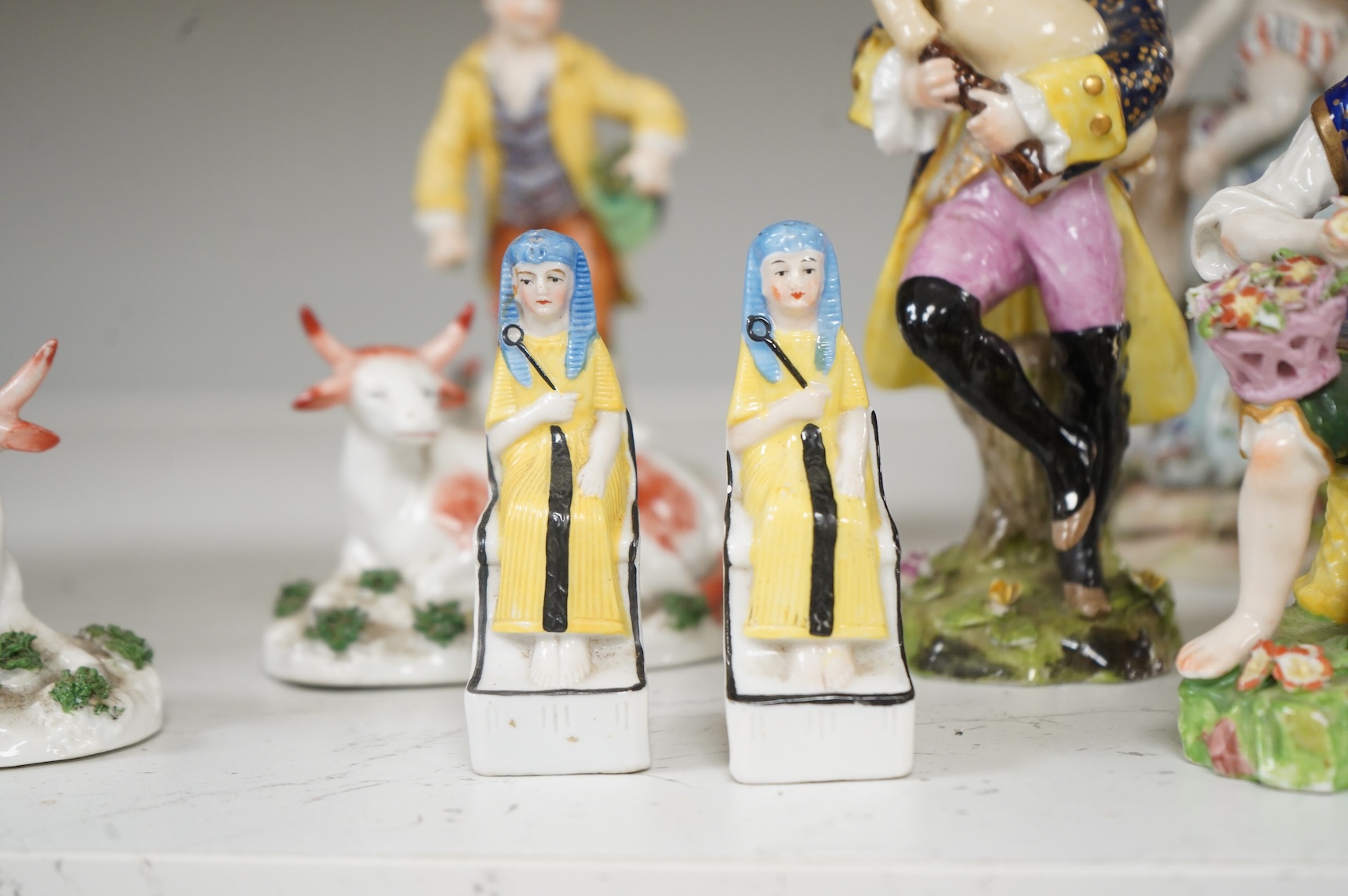 Two Derby porcelain seated figures emblematic of summer and autumn and a collection of Continental porcelain figures to include a pair of recumbent cows, largest 18cm high